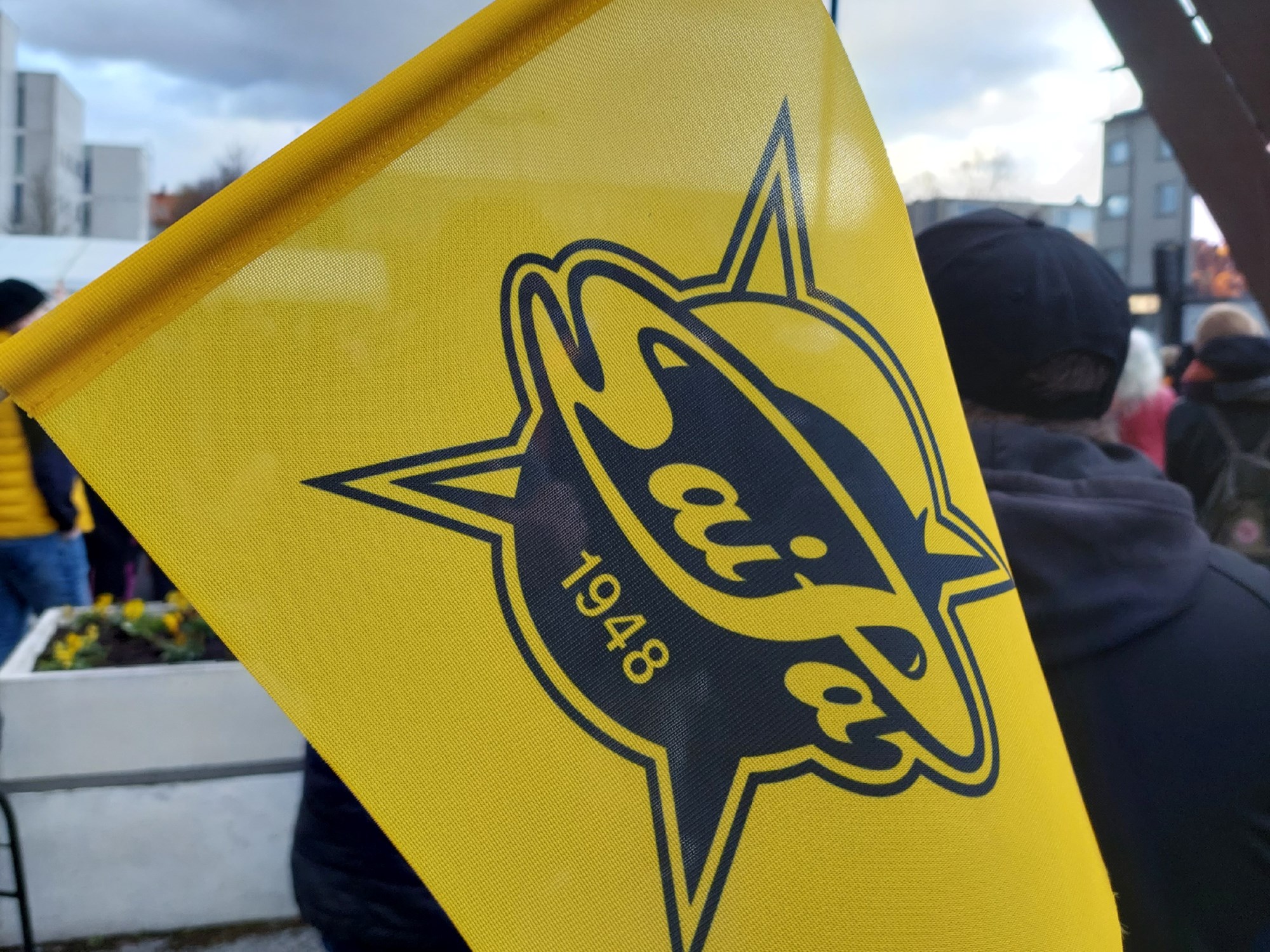 SaiPa-jääkiekkojoukkueen lippu, taustalla ihmisiä Kauppatorilla.